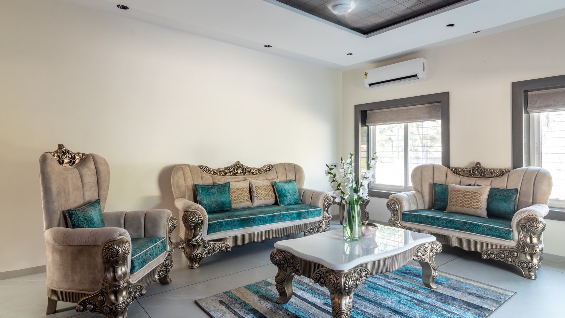 Living room with carved gilt-finish sofas, teal upholstery and a marble-top coffee table — Ramkrushnahari, Karandi